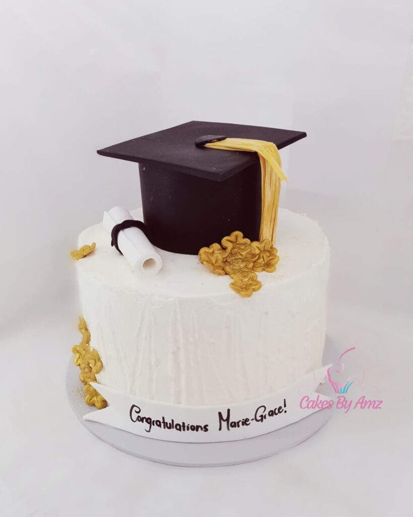 White graduation cake with fondant cap and gold detail